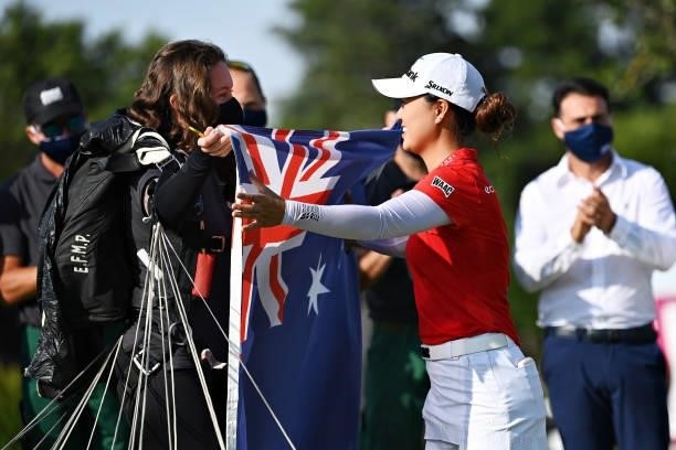 Tournament winner Minjee Lee of Australia is presented with an Australia flag by a parachutist landing on the eighteenth green during day four of the...