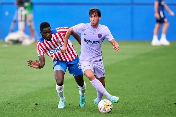 Sergi Roberto of FC Barcelona competes for the ball with Ibrahim Kebe of Girona FC during a friendly match between FC Barcelona and Girona FC at...