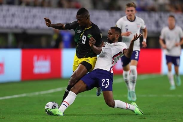 Kellyn Acosta of United States and Cory Burke of Jamaica fight for the ball during to the a quarterfinal match between United States and Jamaica as...