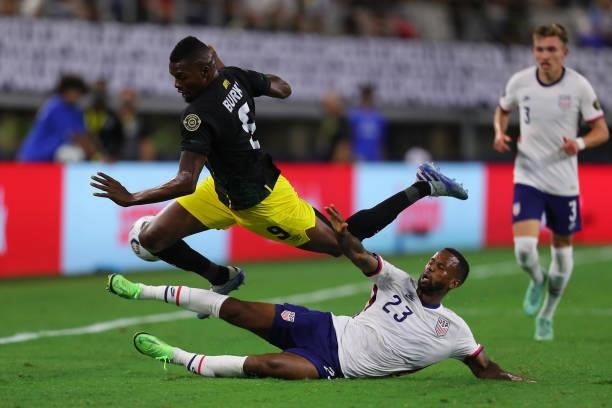 Kellyn Acosta of United States and Cory Burke of Jamaica fight for the ball during to the a quarterfinal match between United States and Jamaica as...