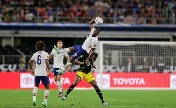 Shaq Moore of the USA goes over the top of Cory Burke of Jamaica during a game between Jamaica and USMNT at AT&T Stadium on July 25, 2021 in Dallas,...