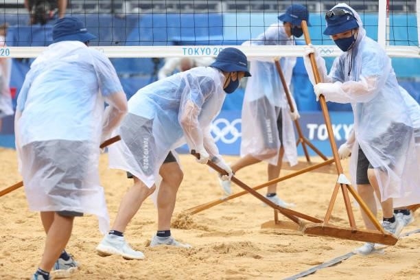 Maintanence crews tend to the court during the Women's Preliminary - Pool B beach volleyball between Team United States and Team Spain on day four of...