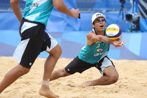 Katsuhiro Shiratori of Team Japan returns the ball against Team Italy during the Men's Preliminary - Pool F beach volleyball on day four of the Tokyo...