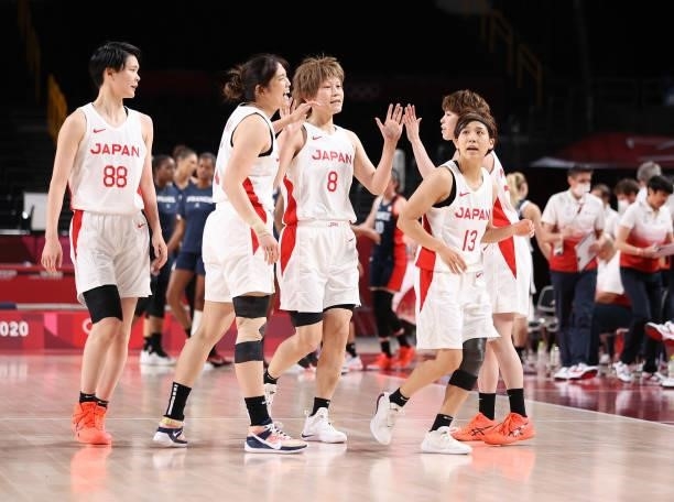 Maki Takada of Team Japan is congratulated by teammates as she comes to the bench for a time out against France during a Women's Preliminary Round...