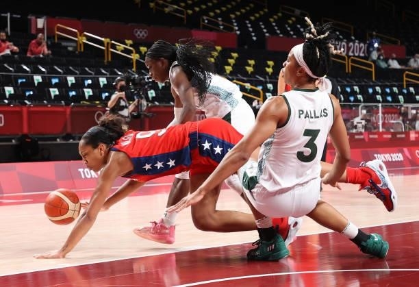 Ja Wilson of Team United States falls between defneders Promise Amukamara and Pallas Kunaiyi-Akpanah of Team Nigeria during the second half of a...