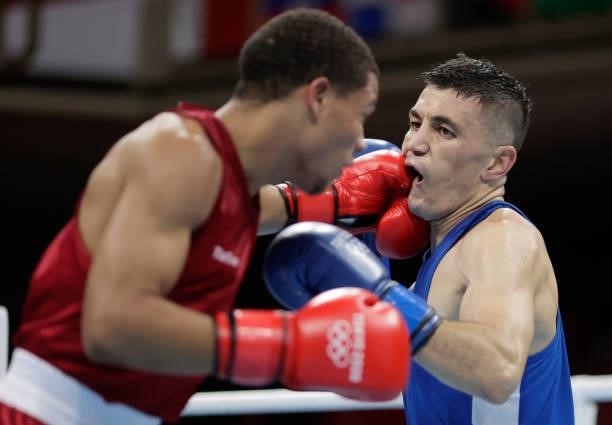 Rohan Polanco Emiliano of Dominican Republic exchanges punches with Bobo Usmon Baturov of Uzbekistan during the Men's Welter on day four of the Tokyo...