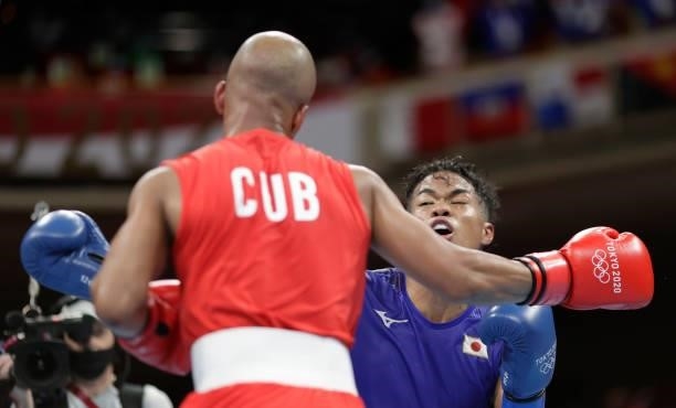 Roniel Iglesia of Cuba exchanges punches with Sewonrets Quincy Mensah Okazawa of Japan during the Meen's Welter on day four of the Tokyo 2020 Olympic...