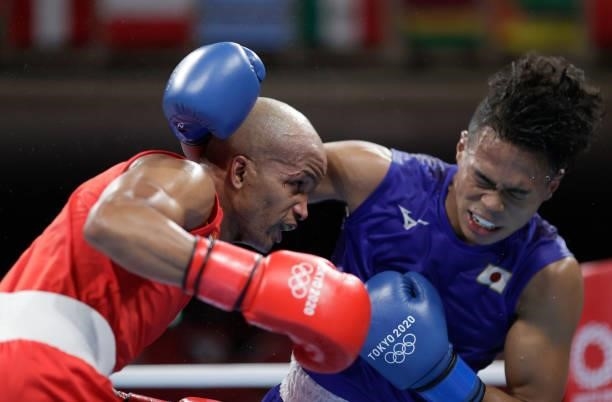 Roniel Iglesia of Cuba exchanges punches with Sewonrets Quincy Mensah Okazawa of Japan during the Men's Welter on day four of the Tokyo 2020 Olympic...