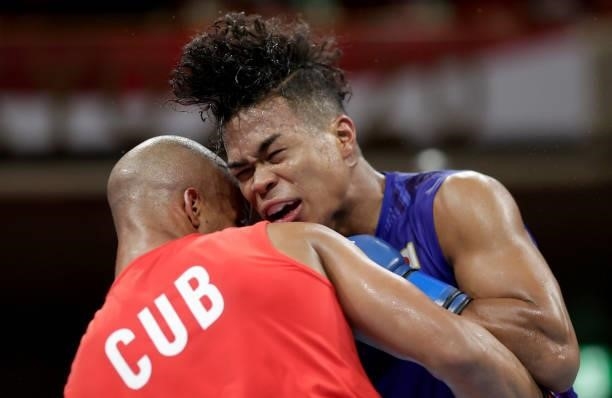 Roniel Iglesia of Cuba exchanges punches with Sewonrets Quincy Mensah Okazawa of Japan during the Men's Welter on day four of the Tokyo 2020 Olympic...