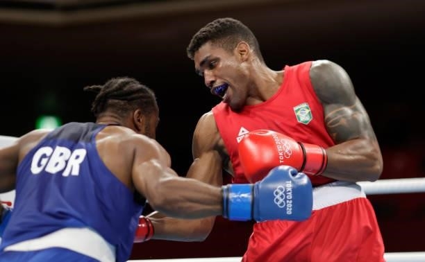 Abner Teixeira of Brazil exchanges punches with Cheavon Clarke of Great Britain during the Men's Heavy on day four of the Tokyo 2020 Olympic Games at...