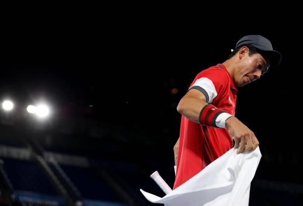 Kei Nishikori of Team Japan towels down during his Men's Singles Second Round match against Marcos Giron of Team USA on day four of the Tokyo 2020...
