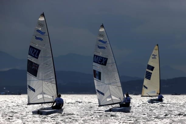 Men's Finn class competitors return to shore following their race on day four of the Tokyo 2020 Olympic Games at Enoshima Yacht Harbour on July 27,...