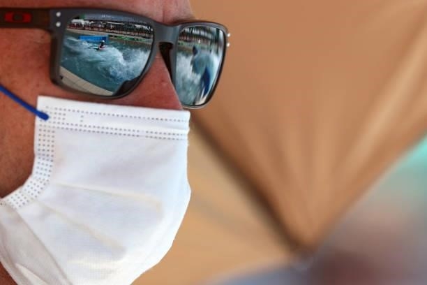 Spectator wears a protective face covering due to the Covid-19 pandemic as Evy Leibfarth of Team United States is reflected in their glasses as she...