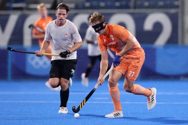 Jip Janssen of Team Netherlands runs with the ball whilst under pressure from John Findlay Hammond Boothroyd of Team Canada during the Men's...