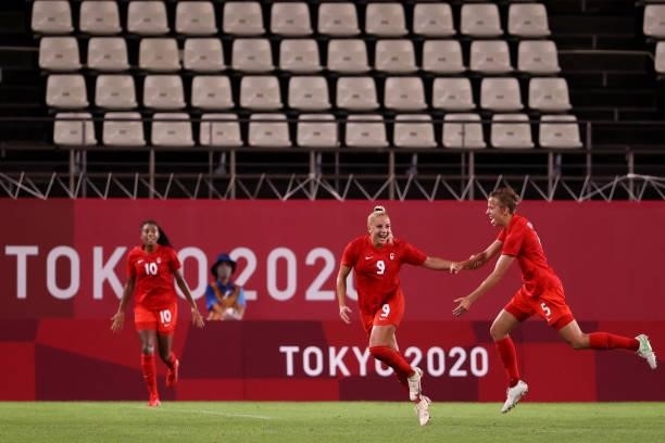 Adriana Leon of Team Canada celebrates with teammate Quinn after scoring their side's first goal during the Women's Group E match between Canada and...
