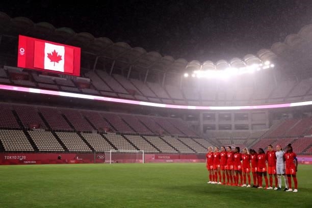 Players of Team Canada stand for the national anthem as empty seats are seen prior to the Women's Group E match between Canada and Great Britain on...