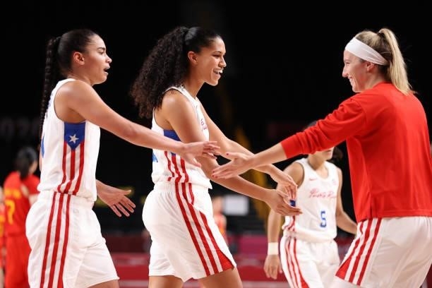 Tayra Melendez and Isalys Quinones of Team Puerto Rico are greeted by Ali Gibson as they walk off the court for a timeout during the second half of...