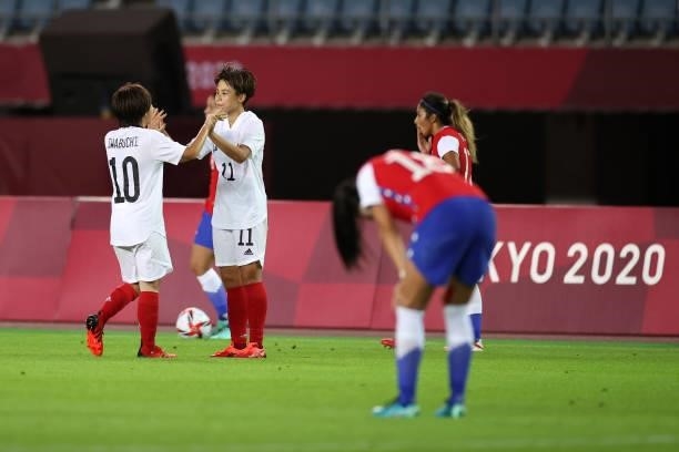 Mina Tanaka of Team Japan celebrates their side's victory with team mate Mana Iwabuchi after the Women's Group E match between Chile and Japan on day...