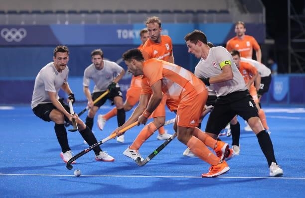 Glenn Schuurman of Team Netherlands holds the ball whilst under pressure from Scott William Martin Tupper of Team Canada during the Men's Preliminary...