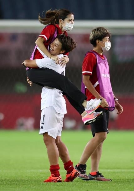 Mina Tanaka of Team Japan celebrates their side's victory with members of staff after the Women's Group E match between Chile and Japan on day four...