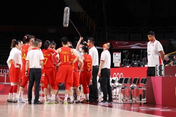 Yao ming looks on as the China Women's Basketball Team huddles together for a timeout during the second half of a Women's Preliminary Round Group C...