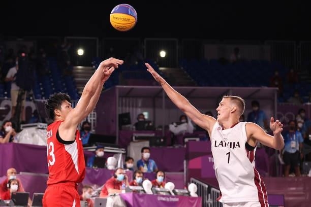 Mai Yamamoto of Team Japan shoots against Nauris Miezis of Team Latvia in the 3x3 Basketball competition on day four of the Tokyo 2020 Olympic Games...