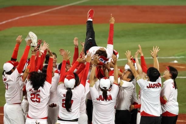Manager Reika Utsugi of Team Japan is thrown in the air by her team after defeating Team United States 2-0 in the Softball Gold Medal Game between...
