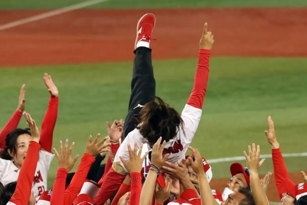Manager Reika Utsugi of Team Japan is thrown in the air by her team after defeating Team United States 2-0 in the Softball Gold Medal Game between...