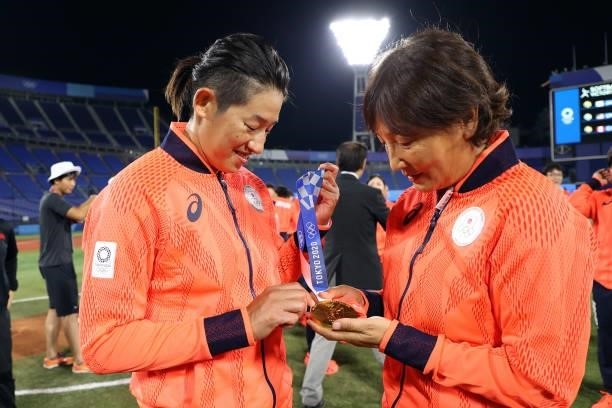 Manager Reika Utsugi and Yukiko Ueno of Team Japan look at their gold medals after defeating Team United States 2-0 in the Softball Gold Medal Game...