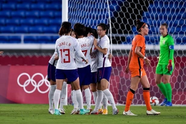 Shanshan Wang of China celebrates with her team mates after scoring her sides first goal past Sari van Veenendaal of the Netherlands during the Tokyo...