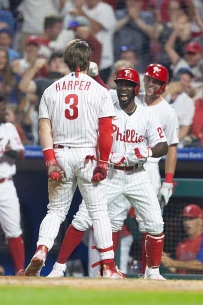 Bryce Harper of the Philadelphia Phillies celebrates with Andrew McCutchen after hitting an inside-the-park home run in the bottom of the fifth...