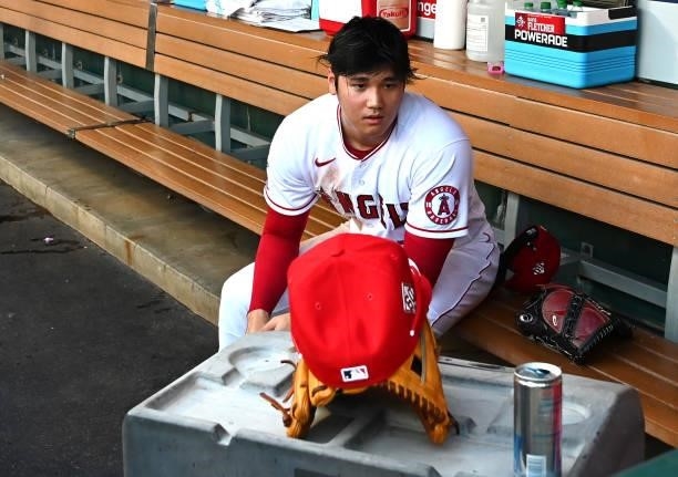Shohei Ohtani of the Los Angeles Angels cools off in front of a fan in the dugout during the game against the Colorado Rockies at Angel Stadium of...