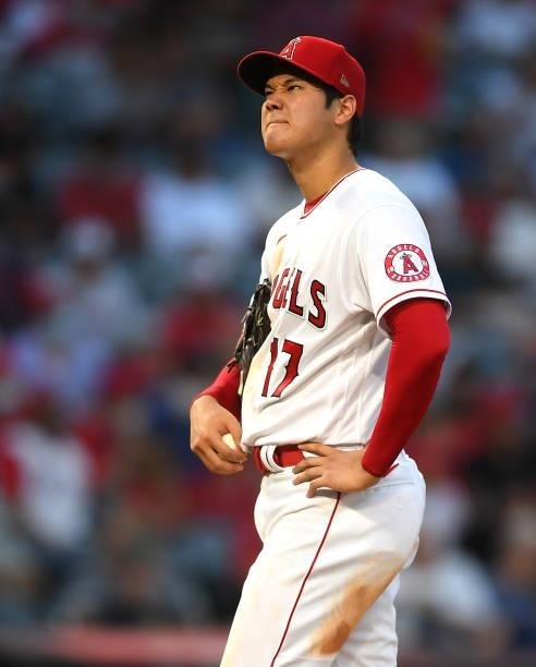 Shohei Ohtani of the Los Angeles Angels reacts on the mound after hitting Trevor Story of the Colorado Rockies with a pitch in the fifth inning of...