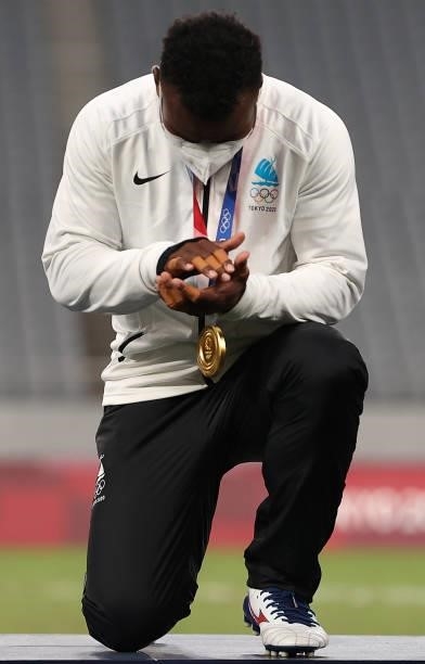 Jerry Tuwai of Team Fiji kneels after receiving his gold medal after his team won the Rugby Sevens Men's Gold Medal match between New Zealand and...