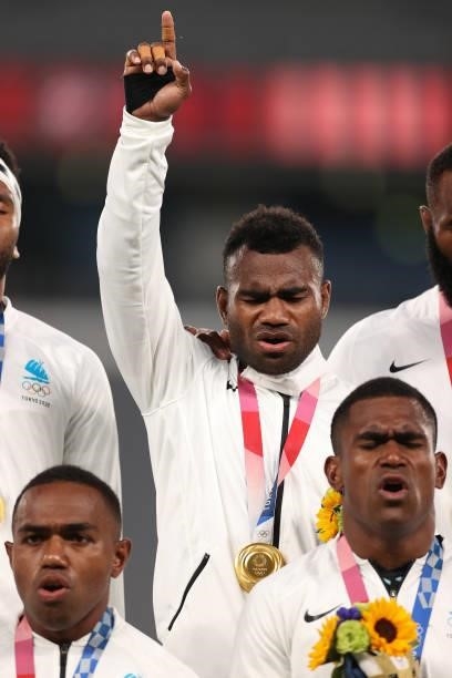 Jerry Tuwai of Team Fiji sings on the podium with his team mates after receiving their gold medals following victory in the Rugby Sevens Men's Gold...