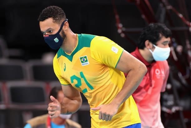 Alan Souza of Team Brazil wears a face mask as he runs on the sidelines against Team ROC during the Men's Preliminary Round - Pool B volleyball on...