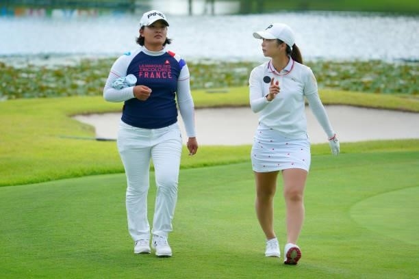 Ai Suzuki and Erika Kikuchi of Japan return to the club house as the play is suspended due to thunder clouds approaching during the first round of...