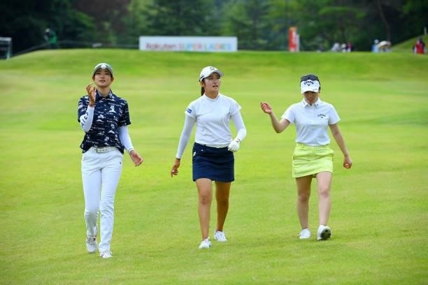 Mone Inami , Erika Hara and Yuna Nishimura of Japan share a laugh while returning to the club house as the play is suspended due to thunder clouds...