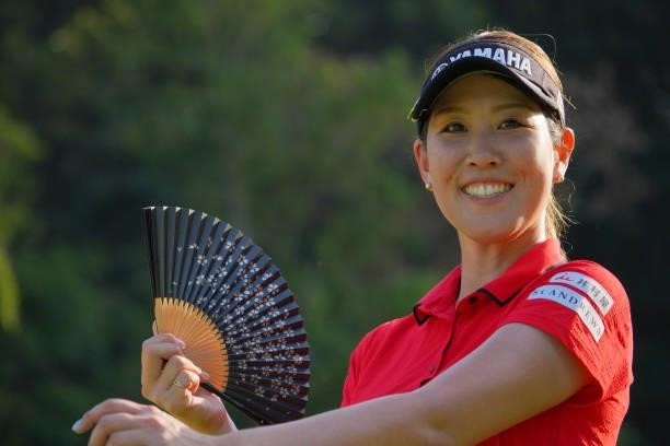 Mami Fukuda of Japan uses a traditional Japanese fan on the 17th tee during the first round of Rakuten Super Ladies at Tokyu Grand Oak Golf Club on...