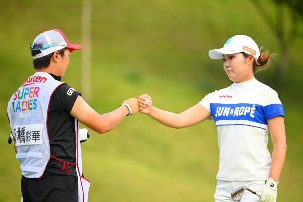 Sayaka Takahashi of Japan fist bumps with her caddie after her chip-in-birdie on the 17th green during the first round of Rakuten Super Ladies at...