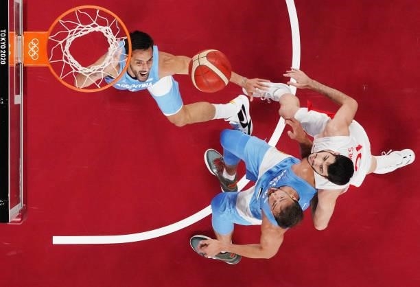 Facundo Campazzo of Team Argentina and teammate Marcos Delia jump for a rebound against Alejandro Abrines Redondo of Team Spain during the first half...