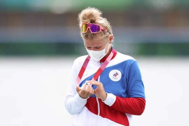 Silver medalist Hanna Prakatsen of Team ROC looks down at her medal during the medal ceremony for the Women's Single Sculls Final A on day seven of...