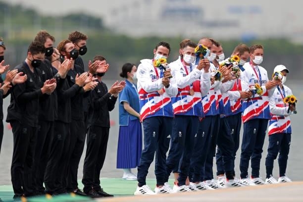 Bronze medalist Team Great Britain cheer for gold medalists Team New Zealand as they receive their medals for Men's Eight Final A on day seven of the...