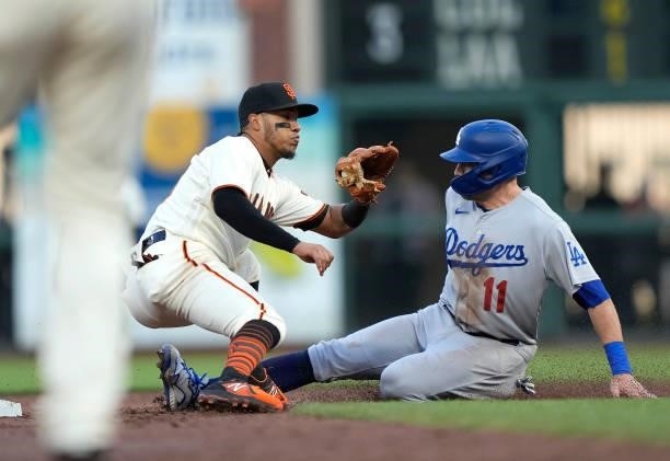 Pollock of the Los Angeles Dodgers steals second base sliding in ahead of the throw to Thairo Estrada of the San Francisco Giants in the top of the...