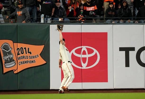 Alex Dickerson of the San Francisco Giants catches a fly ball at the wall off the bat of Cody Bellinger of the Los Angeles Dodgers in the top of the...