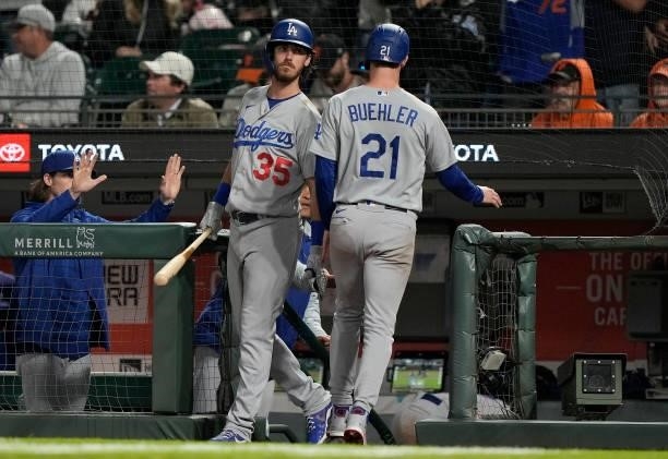 Walker Buehler of the Los Angeles Dodgers is congratulated by Cody Bellinger after Buehler scored against the San Francisco Giants in the top of the...