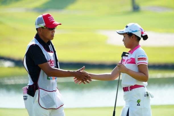 Nana Suganuma of Japan shakes hands with her caddie after holing out on the 18th green during the second round of Rakuten Super Ladies at Tokyu Grand...