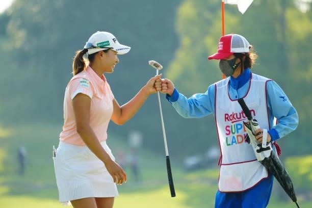 Hinako Shibuno of Japan fist bumps with her caddie after holing out on the 18th green during the second round of Rakuten Super Ladies at Tokyu Grand...