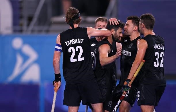 Kane Russell of Team New Zealand celebrates with teammates after scoring their team's first goal during the Men's Preliminary Pool A match between...