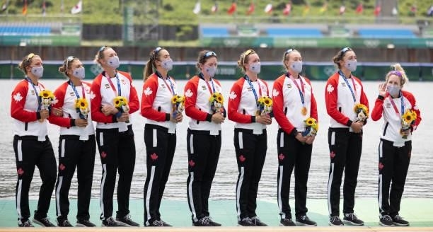 Coxswain Kristen Kit gestures for the crew to sing louder as Canada's national anthem is played during the medal ceremony for during the medal...